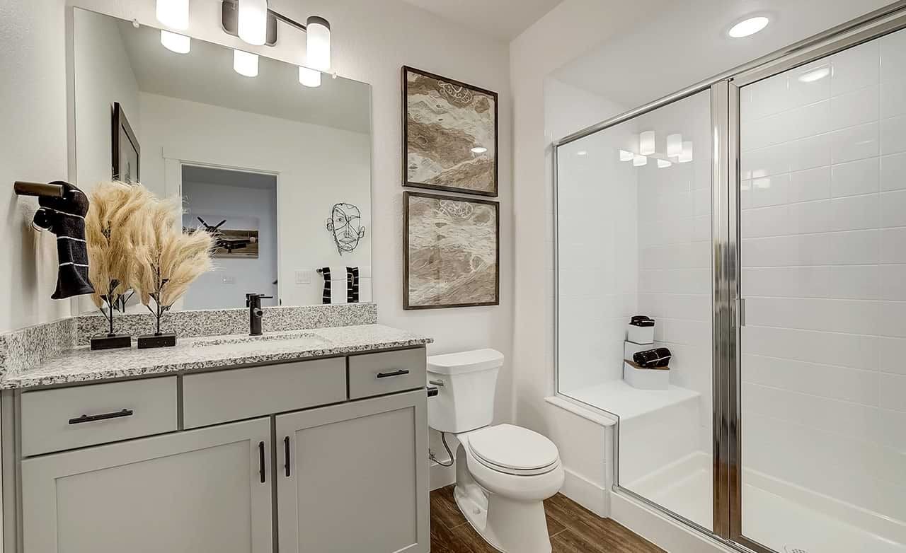 Modern bathroom with granite countertop and glass shower in Westerly community.