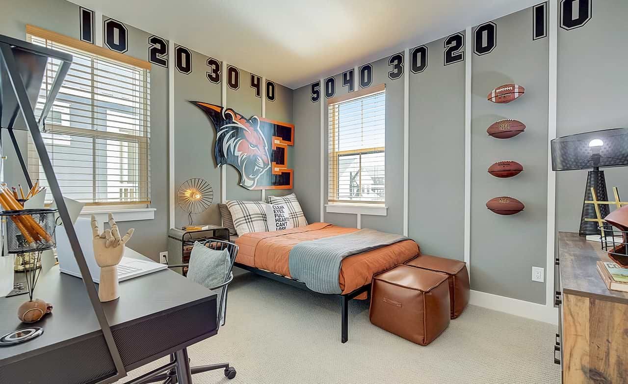 Modern bedroom with sports decor, gray walls adorned with football motif, located in Westerly community.