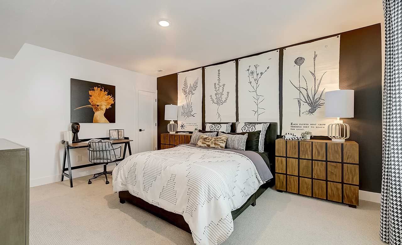 Modern bedroom with botanical art, warm lamps, stylish desk, and elegant bedding in Westerly home.