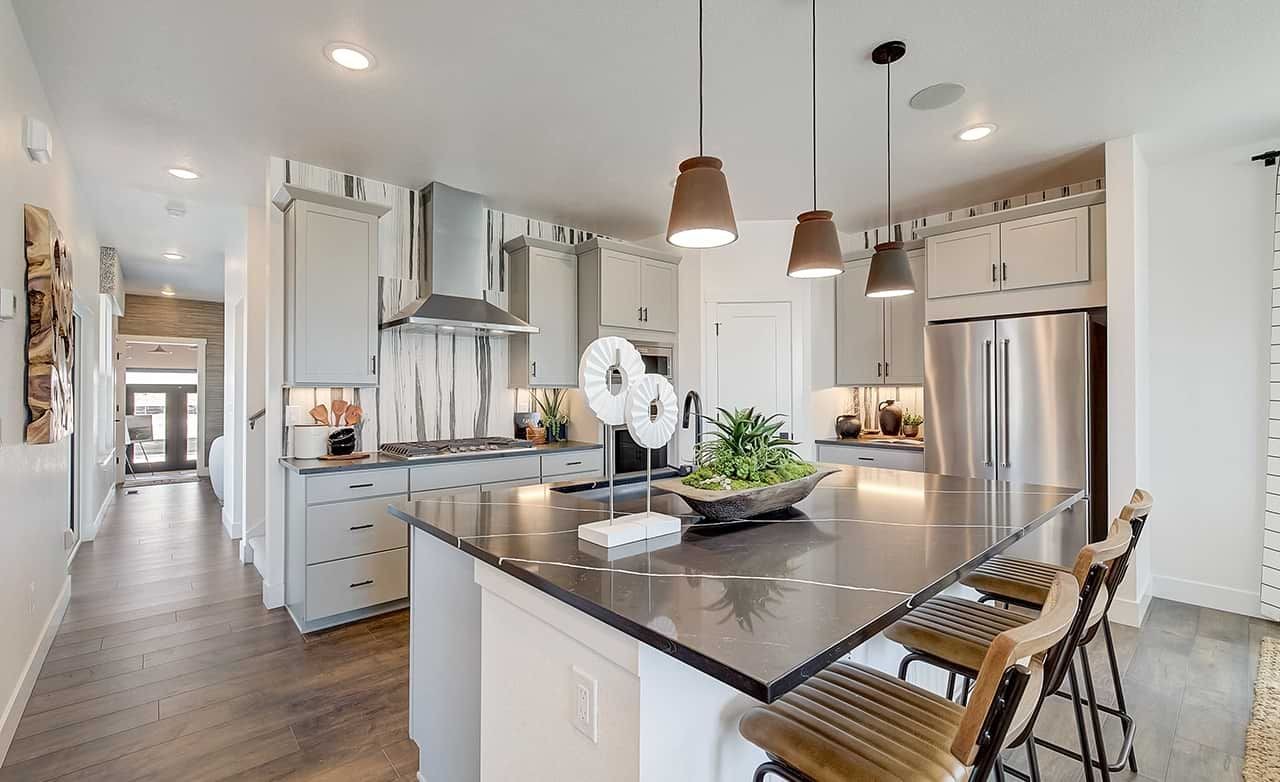 Modern kitchen with quartz island, pendant lights, stainless steel appliances, Westerly location.