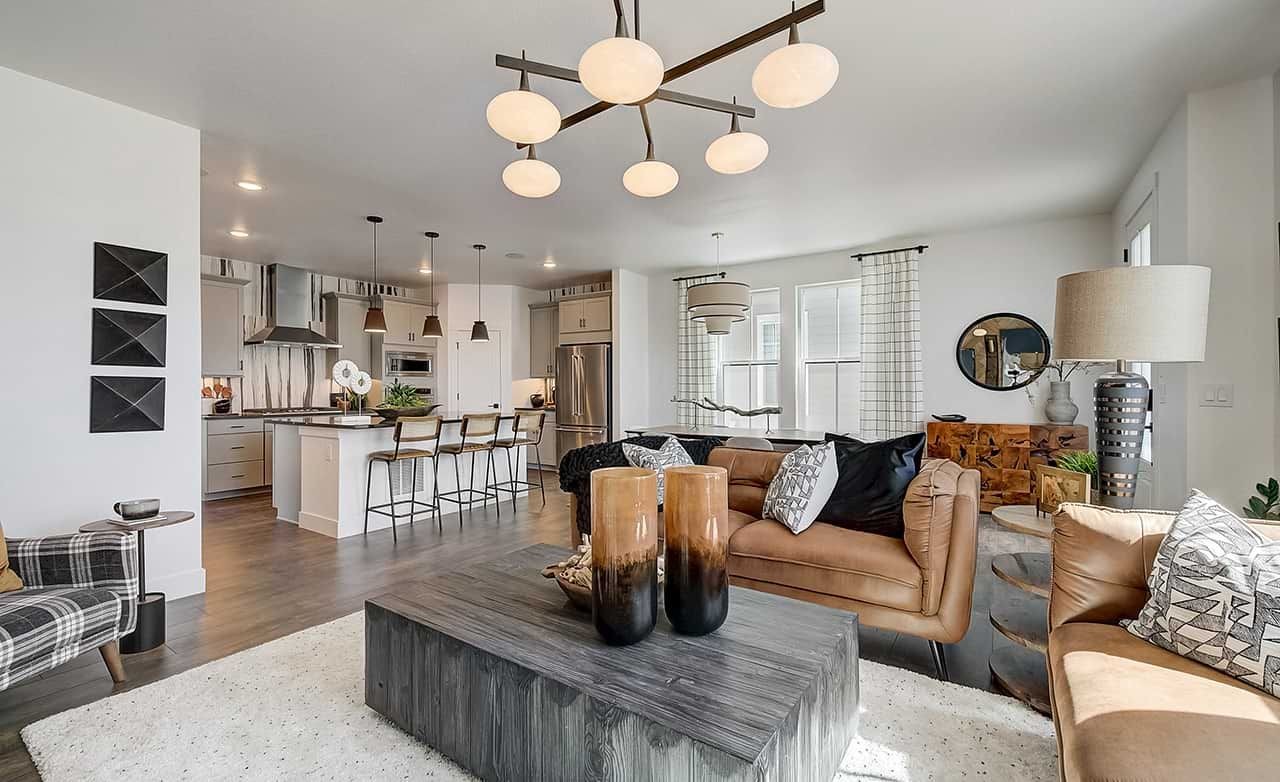 Modern living space with open kitchen, pendant lights, and chic decor in Westerly community.