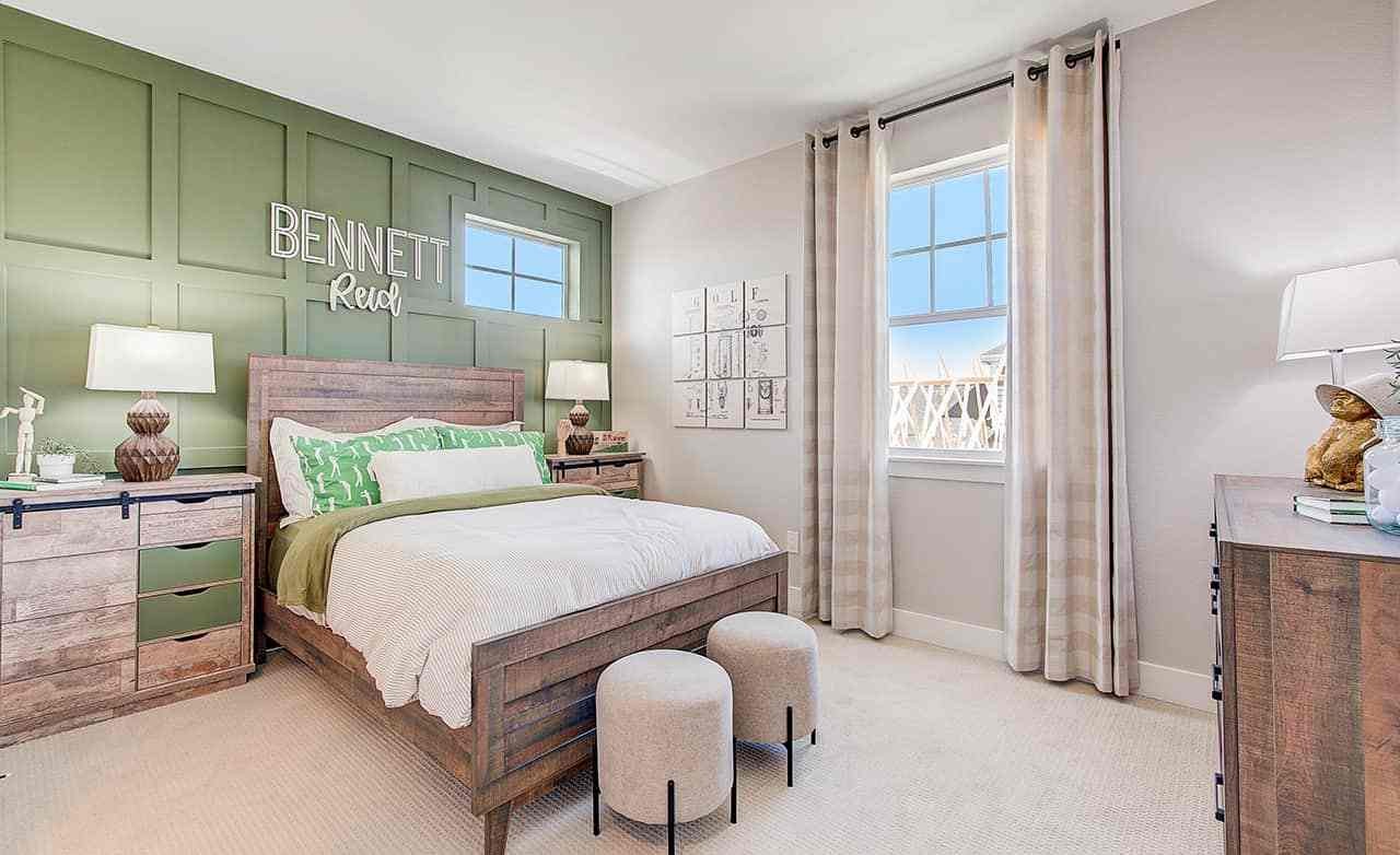 Stylish bedroom features wooden furniture, green accent wall, elegant decor, Westerly community.