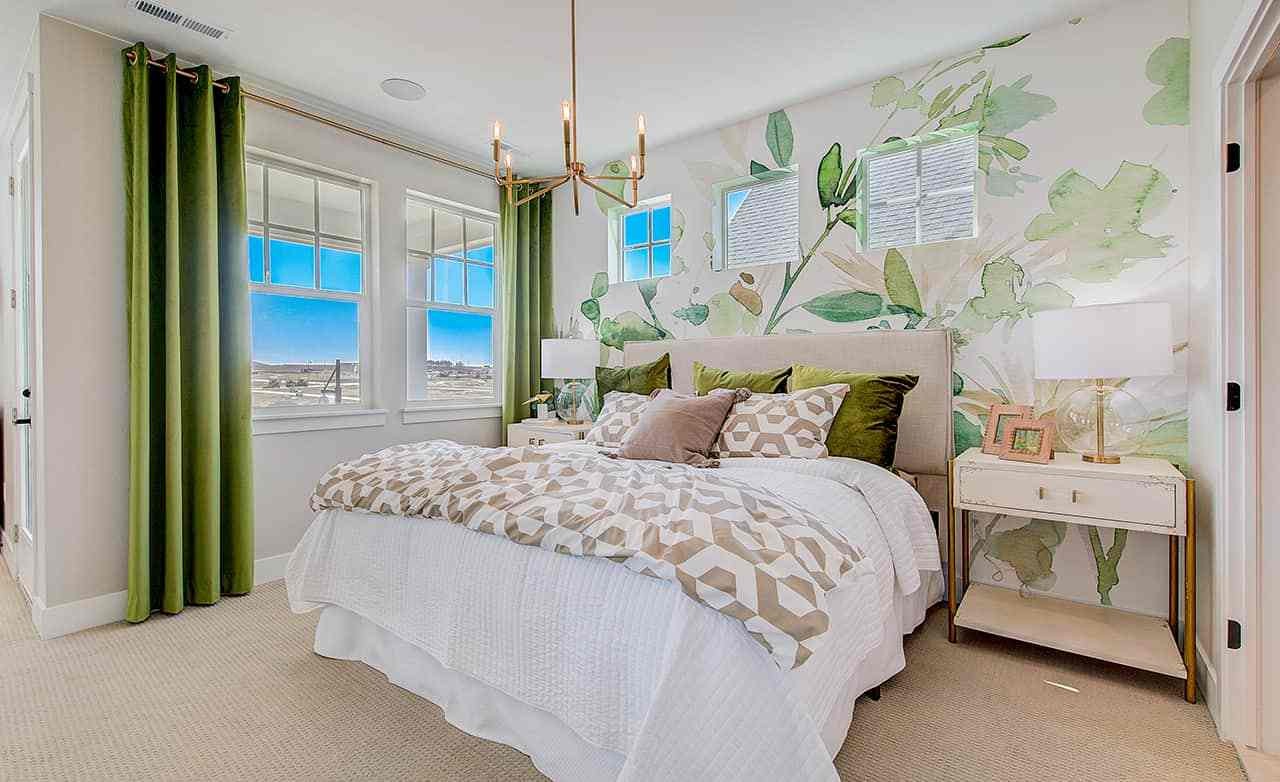 Elegant bedroom with leafy wallpaper, green curtains, and plush bedding in Westerly community, highlighting luxury design.