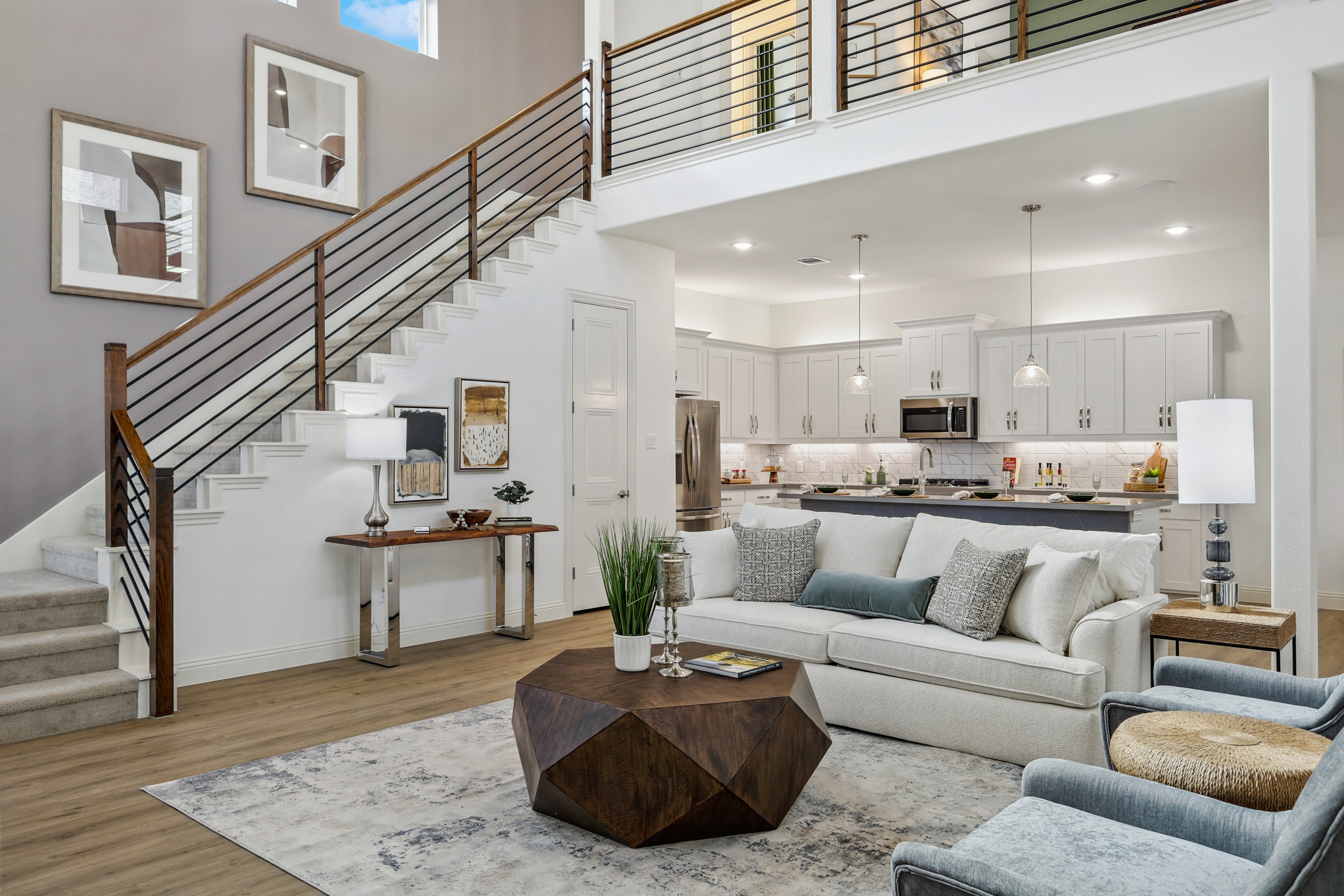 Luxurious Solterra Texas Home Living Room and Kitchen Design Spacious Solterra Texas living room, modern kitchen, elegant staircase with wood railing, large windows.