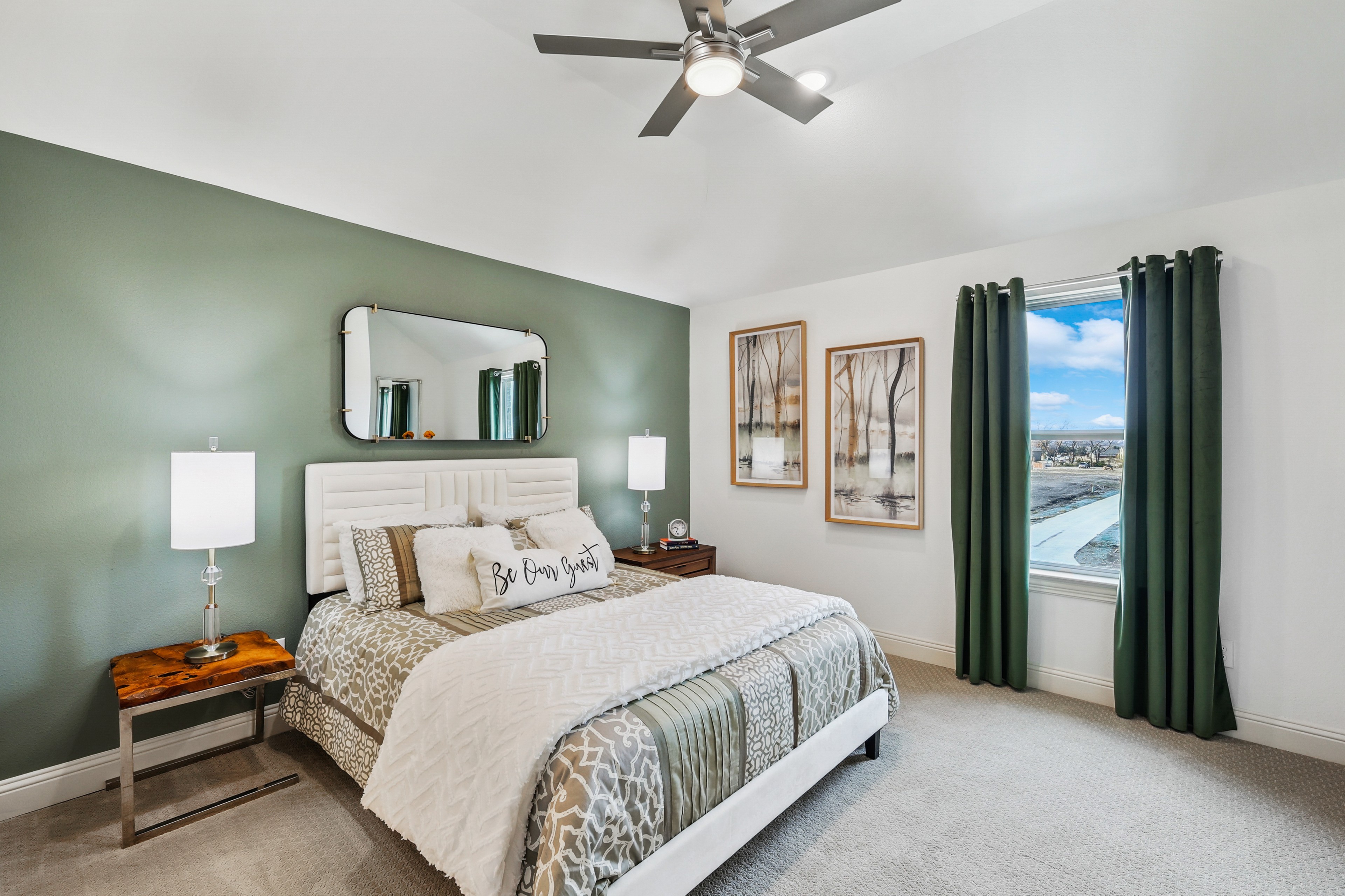 Elegant Bedroom Design in Solterra Texas Community Luxurious bedroom with green accent wall, large window, stylish decor in Solterra Texas community.