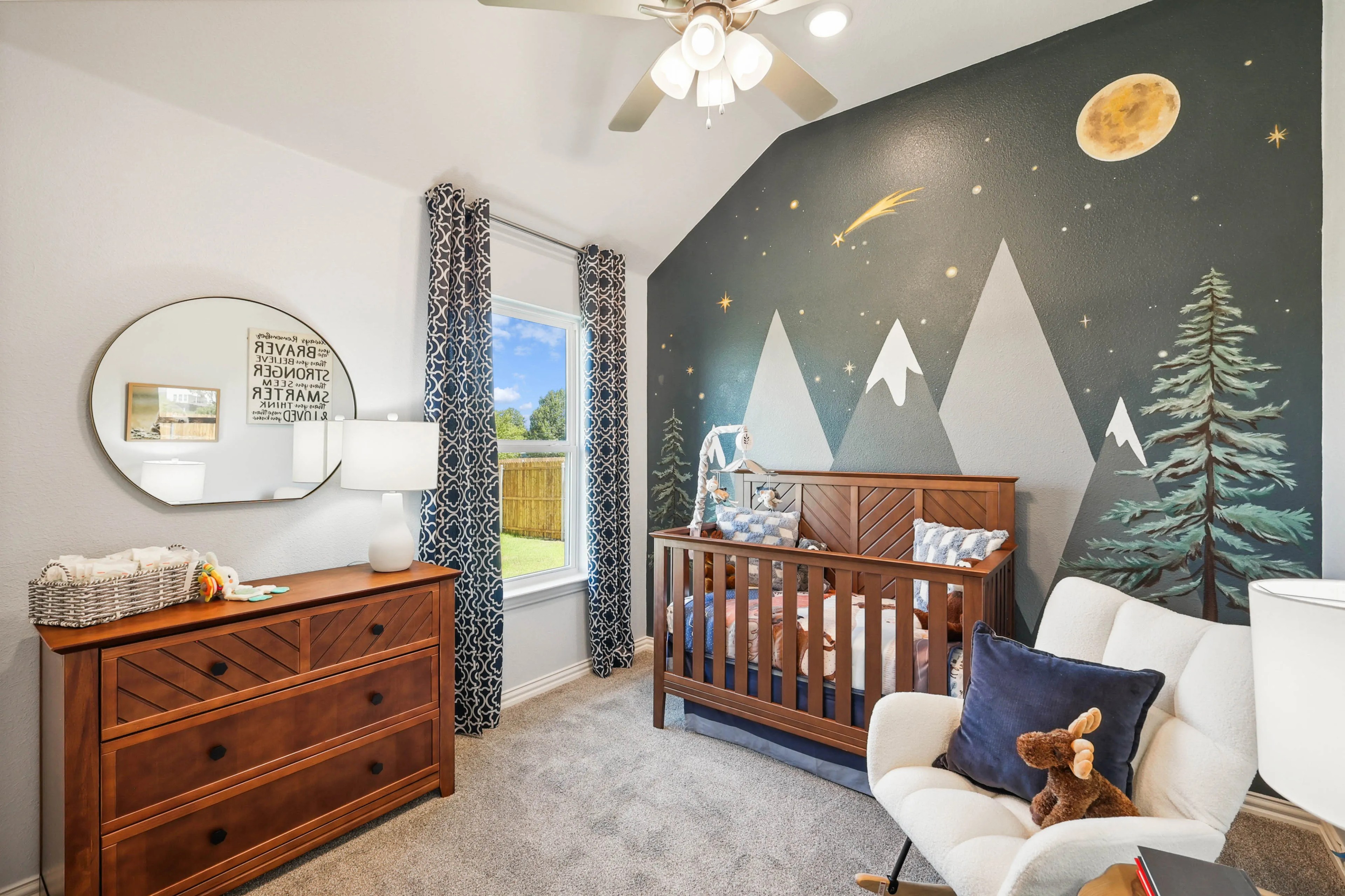 Nursery with Mountain Mural in Pebblebrook Community Stylish nursery with mountain mural, dark wood crib, dresser, Pebblebrook community.