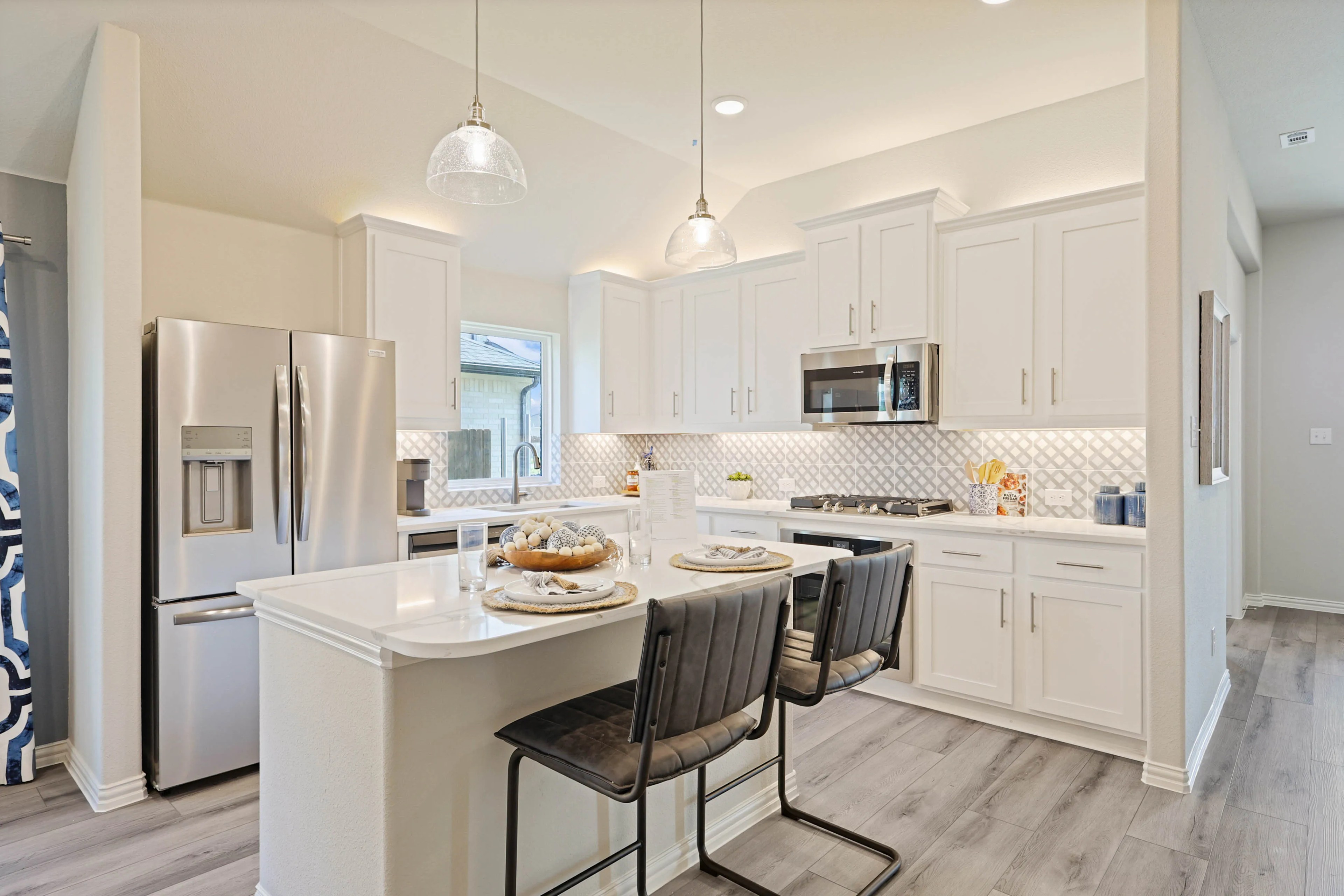Modern Pebblebrook Kitchen with White Cabinets and Stainless Appliances Modern kitchen in Pebblebrook; white cabinets, stainless steel appliances, geometric backsplash, island seating.