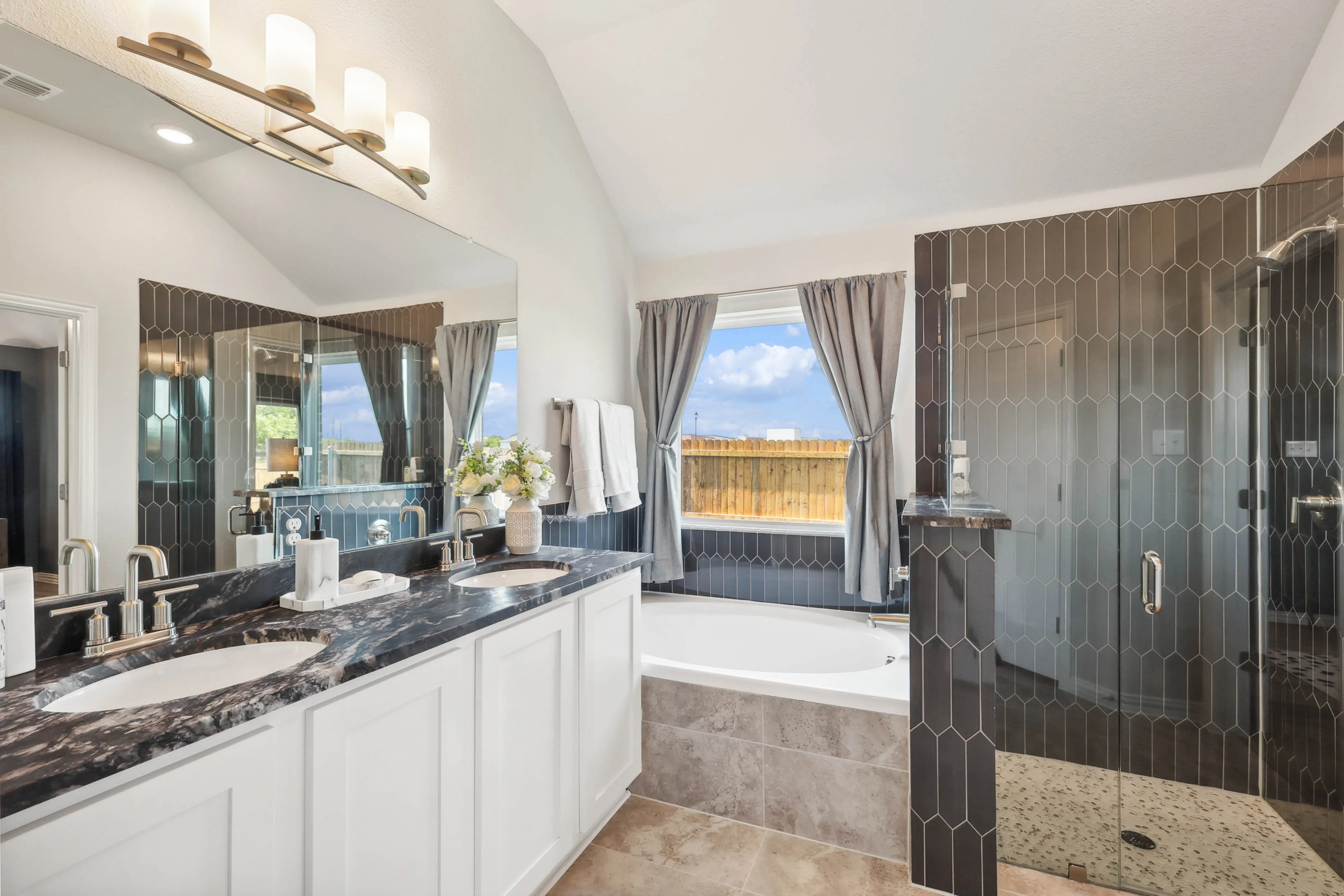 Luxurious Pebblebrook Bathroom with Marble Countertop and Glass Shower Luxurious bathroom with dual sinks, marble countertop, large mirror, glass shower in Pebblebrook community.