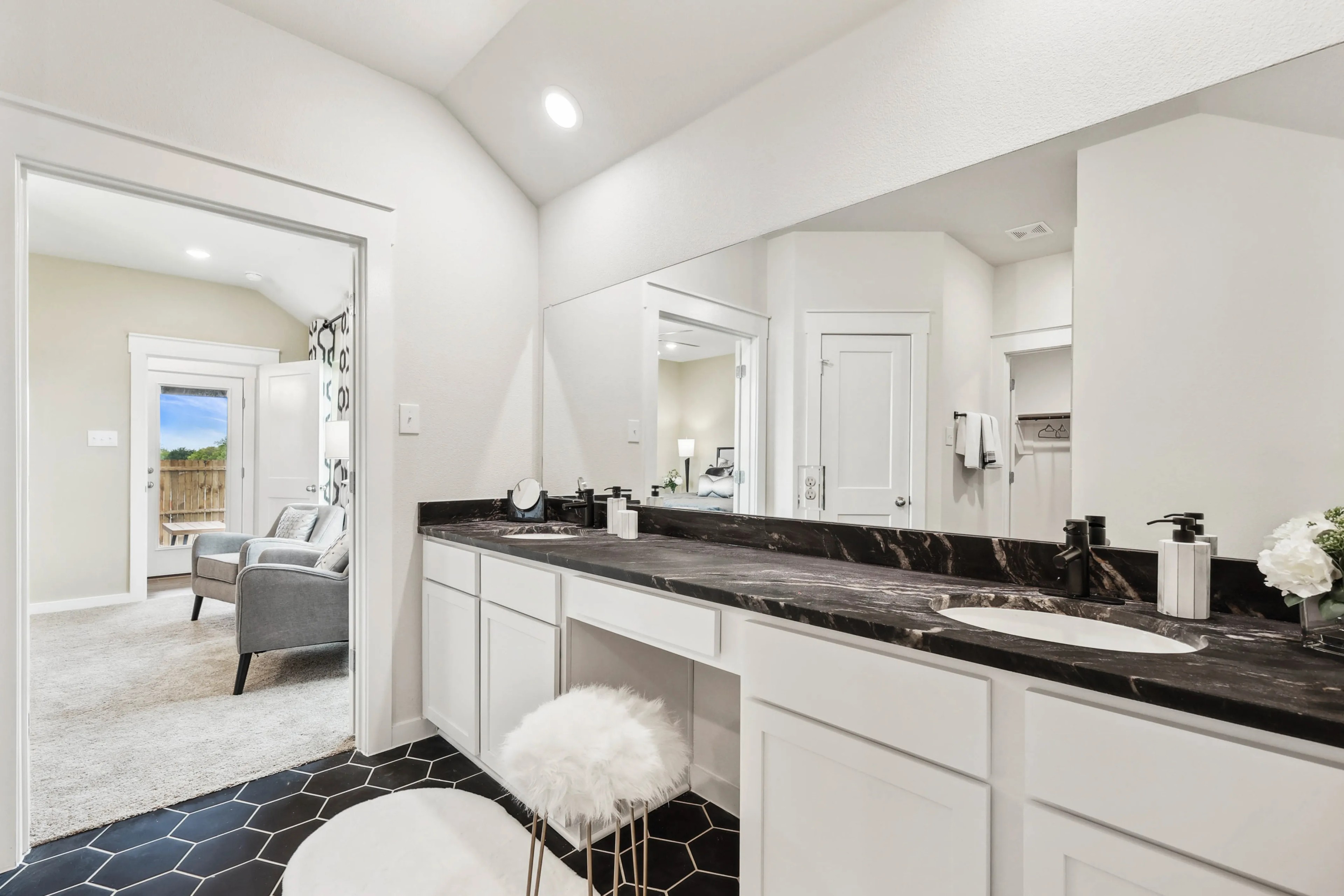 Luxurious Bathroom with Black Marble in Simpson Crossing Home Modern bathroom with black marble countertop, hexagonal tiles, and bright lighting in Simpson Crossing community.