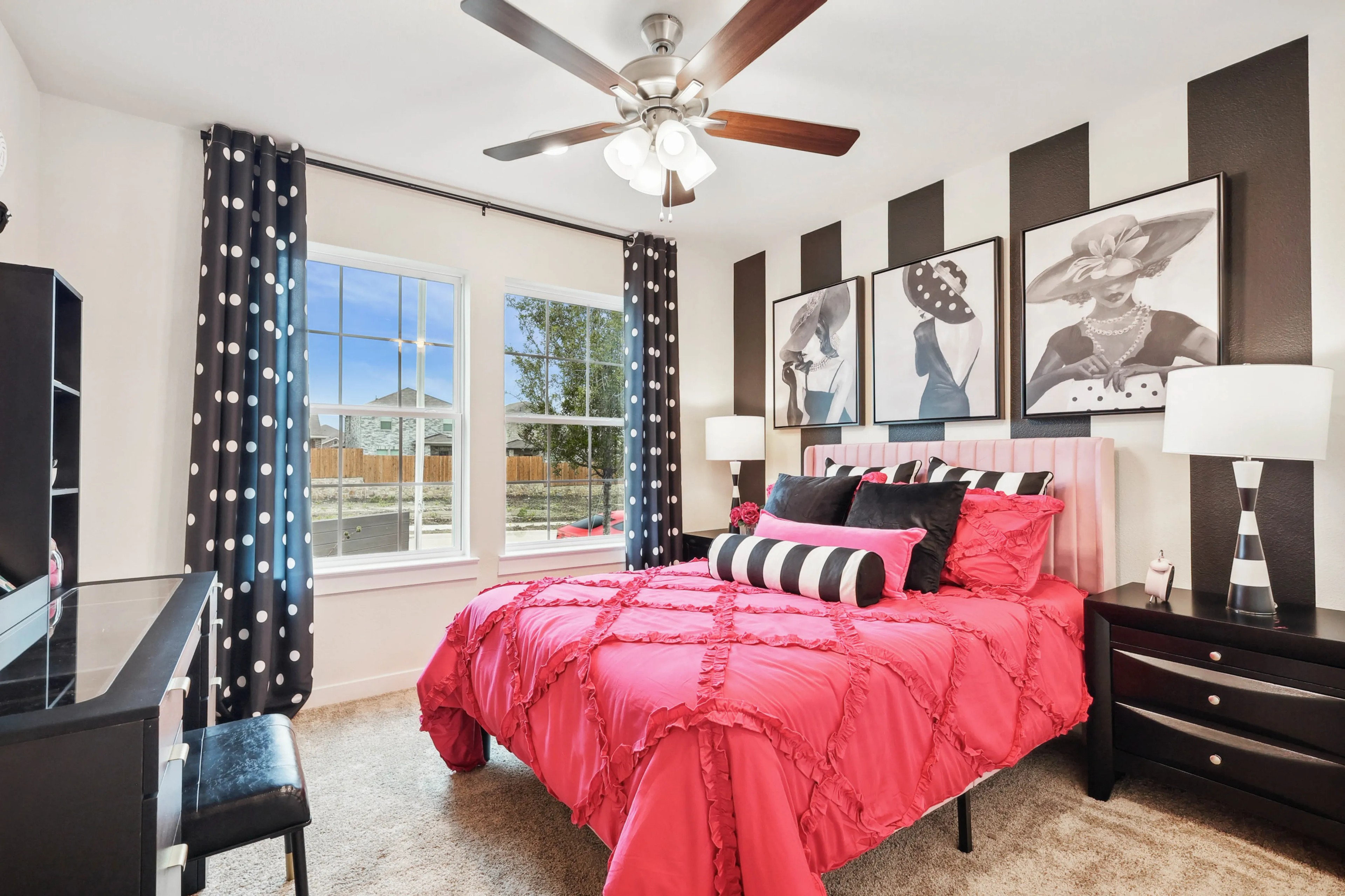 Luxury Bedroom with Pink Bedding and Polka Dot Decor in Simpson Crossing Vibrant bedroom with pink bedding, striped art, polka dot curtains, large windows, Simpson Crossing community.