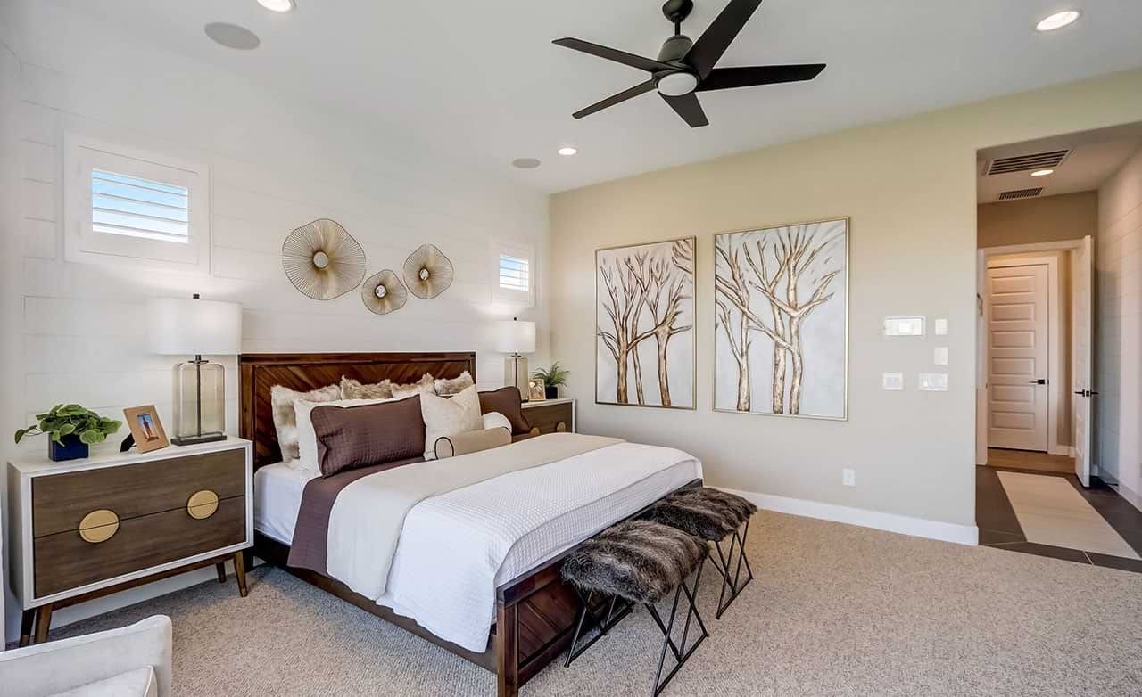 Luxury Bedroom in Canyon Views Hacienda Community Elegant bedroom in Canyon Views with modern décor, wall art, and ceiling fan. Neutral tones and natural light.