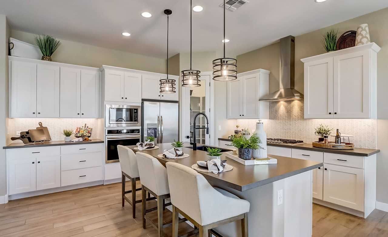 Modern Kitchen Design in Hacienda Community with White Cabinetry Modern kitchen with white cabinetry, island, and pendant lights in Hacienda community.