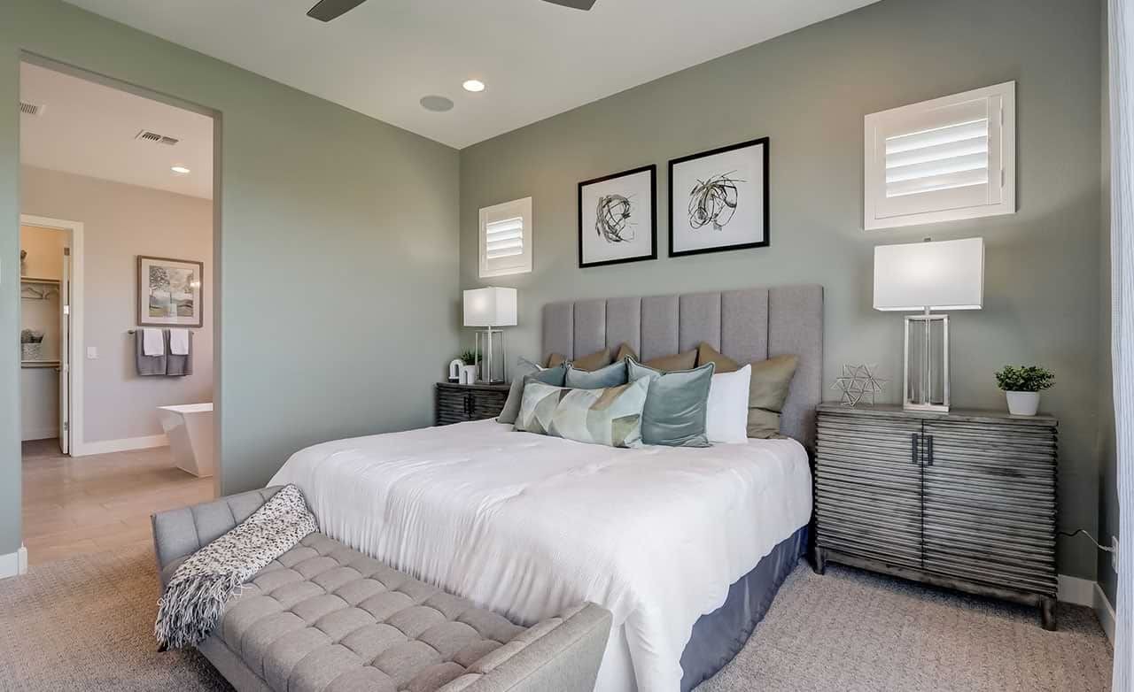 Luxurious Bedroom Design in Hacienda Community Elegant bedroom with plush bedding, gray headboard, modern art, stylish lamps in Hacienda community.
