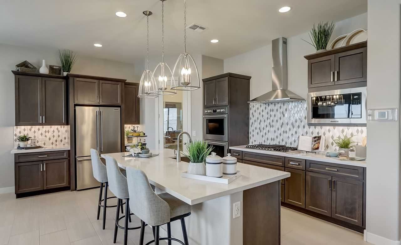 Modern Kitchen in Canyon Views Hacienda Community with Dark Cabinets Modern kitchen with dark cabinets, island, pendant lights, stainless steel appliances in Canyon Views Hacienda community.