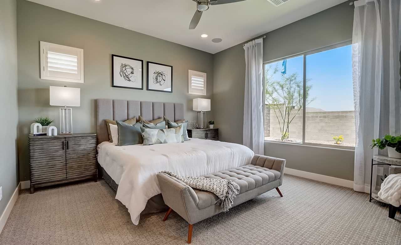 Luxurious Bedroom in Canyon Views Hacienda Community Elegant bedroom with tufted bench, plush bedding, large window, modern decor in Hacienda community, Canyon Views.