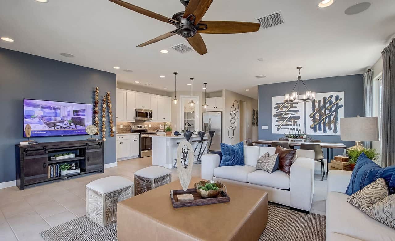 Elegant Living Room and Kitchen Design at Anderson Parc, Arizona Stylish living room with sleek ceiling fan, chic decor, and open kitchen at Anderson Parc, Arizona.
