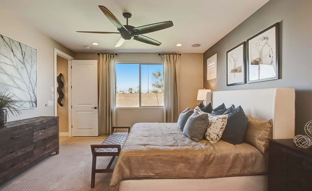 Modern Bedroom Design with Art in Castillo, Anderson Parc, Arizona Modern bedroom with beige decor, ceiling fan, large window, and contemporary art at Castillo, Anderson Parc, Arizona.