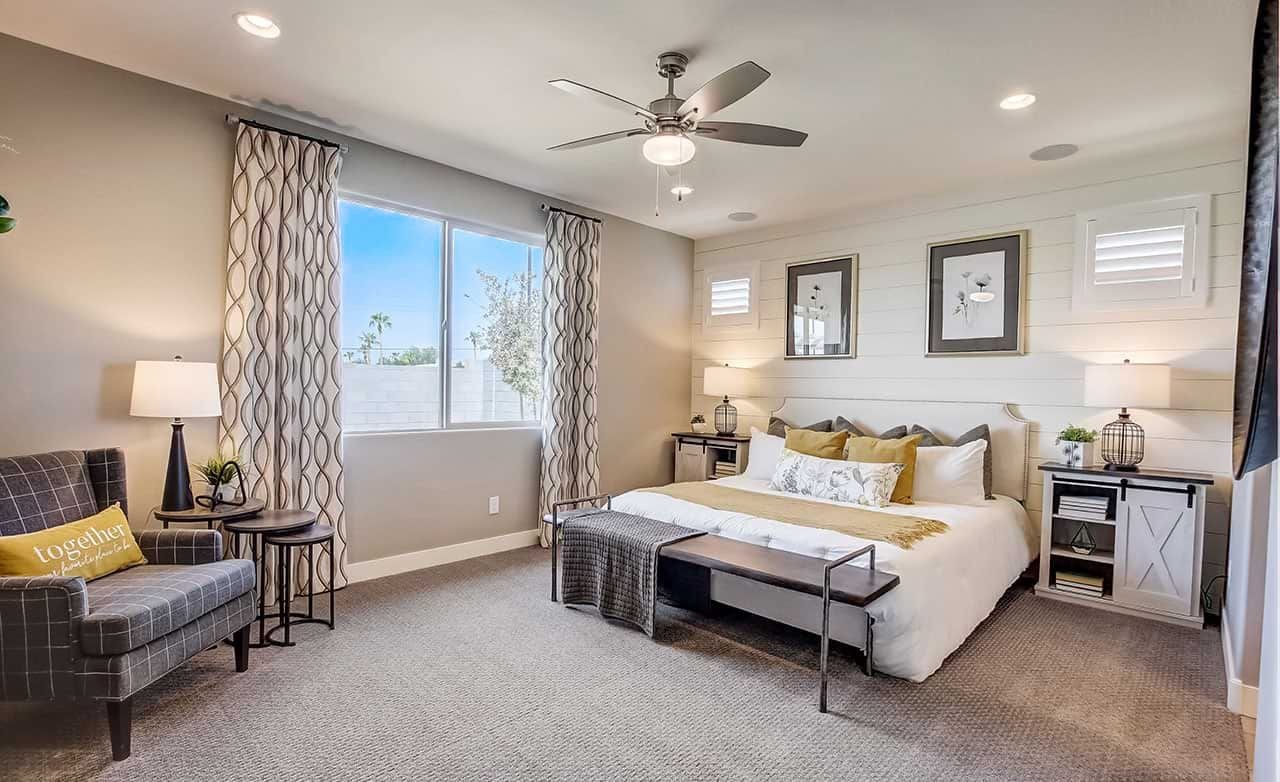 Stylish Bedroom with Shiplap Wall in Castillo at Anderson Parc Elegant bedroom with large window, ceiling fan, cozy seating, shiplap wall in Castillo at Anderson Parc.