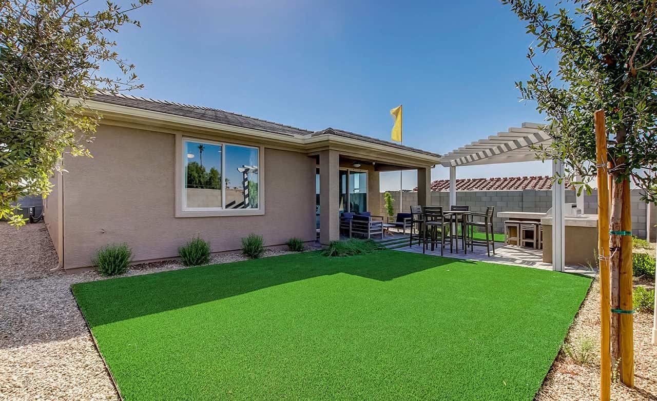 Modern Home with Pergola Patio in Anderson Parc, Arizona Modern home with pergola-covered patio, lush lawn in Anderson Parc, captures Arizona outdoor living.