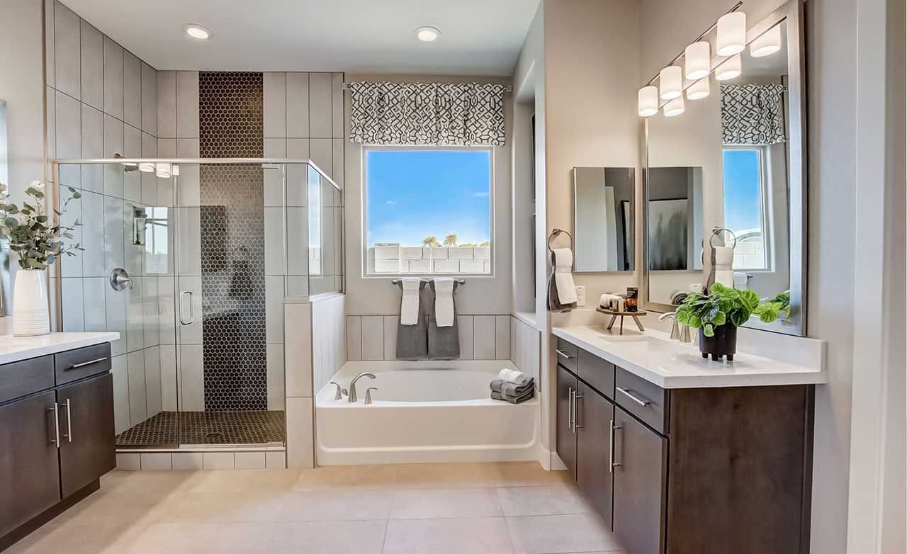 Luxurious Mirada Crossing Bathroom with Modern Design Features Modern bathroom with sleek dark cabinets, glass shower, and tub in Mirada Crossing. Elegant fixtures, bright window view.
